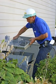 Air Condition service man holding fan by home