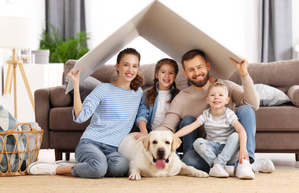 Family with dog seated on floor and smiling