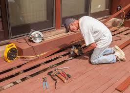 Carpenter on his knees installing florr boards