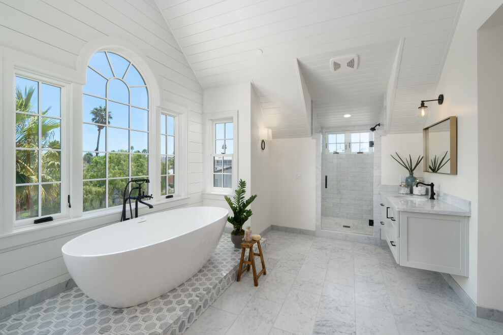 all white bathroom remodel with oval tub in front of classical bay windows