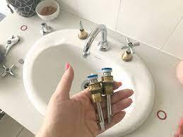 Woman holding two parts to vanity sink