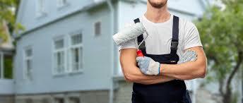 Painter with arms crossed and paint roller in hand