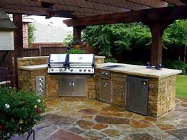 Outdoor kitchen erected on free form stone flooring