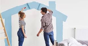 Couple painting wall with blue paint