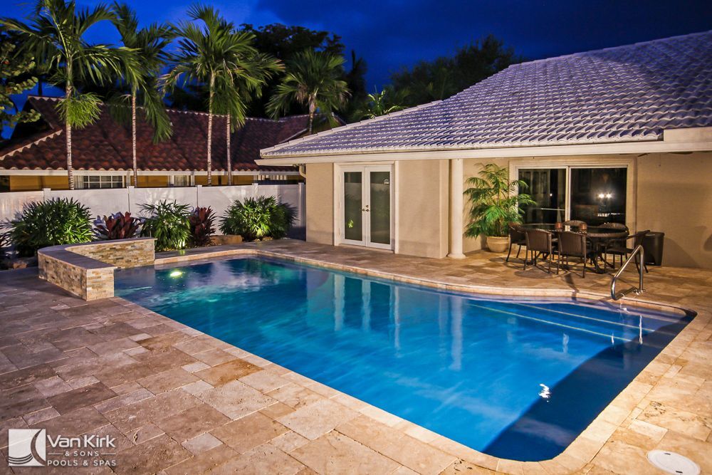 Backyard pool at evening featuring stone pool deck