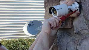 Worker installing remotes security camera