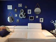 Living area painted dark blue behind wall hangings