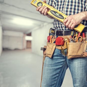 Worker waring tool belt holding a 2ft Level